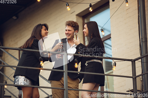 Image of Group of young caucasian people celebrating, look happy, have corporate party at office or bar