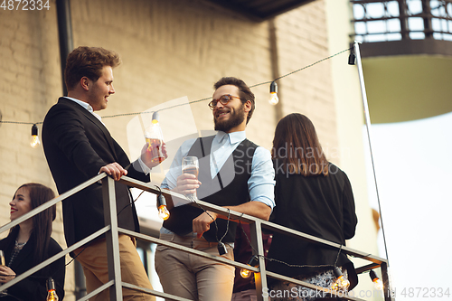 Image of Group of young caucasian people celebrating, look happy, have corporate party at office or bar