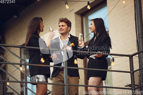 Image of Group of young caucasian people celebrating, look happy, have corporate party at office or bar