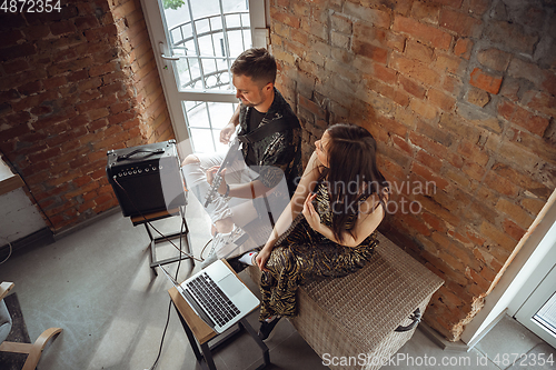 Image of Caucasian musicians during online concert at home insulated and quarantined, cheerful and happy, top view