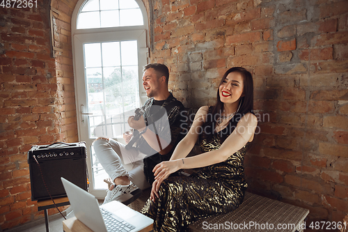 Image of Caucasian musicians during online concert at home insulated and quarantined, cheerful and happy, impressive improvising