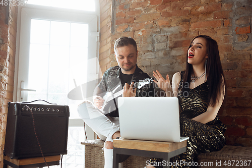 Image of Caucasian musicians during online concert at home insulated and quarantined, cheerful and happy