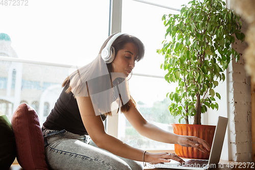 Image of Caucasian female singer during online concert at home insulated and quarantined, cheerful and happy, preparing for perfomance