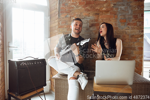 Image of Caucasian musicians during online concert at home insulated and quarantined, cheerful and happy, impressive improvising