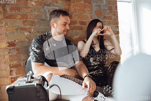 Image of Caucasian musicians preparing for concert at home insulated and quarantined, supporting audience before the start