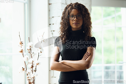 Image of Beautiful african-american well-dressed businesswoman looks confident and busy, successful