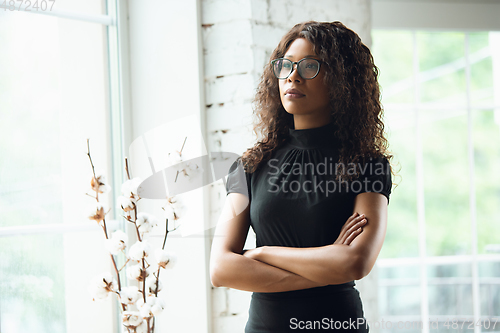 Image of Beautiful african-american well-dressed businesswoman looks confident and busy, successful