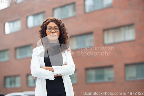 Image of Beautiful african-american well-dressed businesswoman looks confident and busy, successful