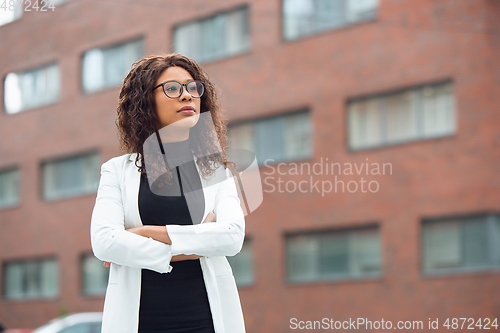 Image of Beautiful african-american well-dressed businesswoman looks confident and busy, successful