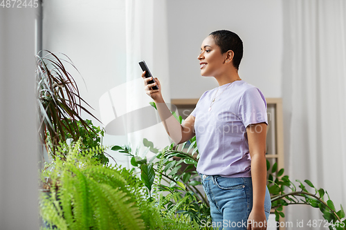 Image of african american woman with smartphone at home