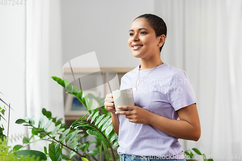 Image of african american woman drinking coffee at home