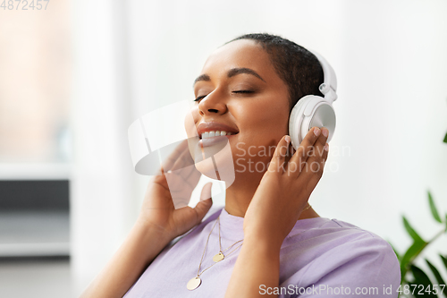 Image of woman in headphones listening to music at home