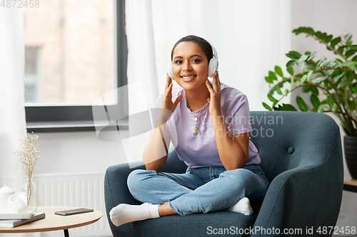 Image of woman in headphones listening to music at home