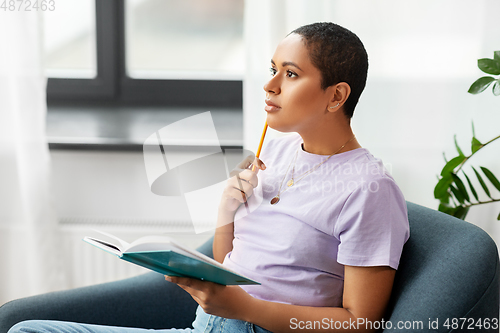 Image of african american woman with diary at home