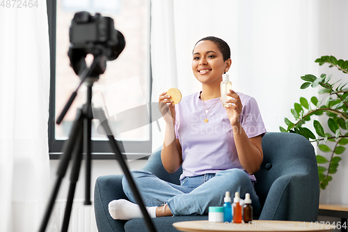 Image of female beauty blogger with camera and cosmetics