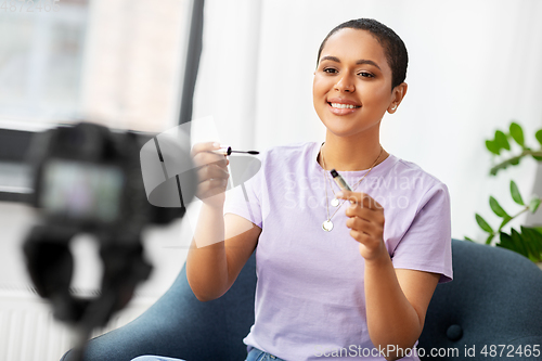 Image of female beauty blogger with camera and mascara