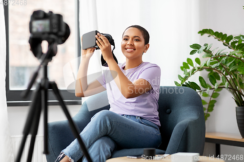 Image of female blogger with camera and vr glasses at home