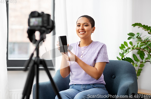 Image of female blogger with camera video blogging at home