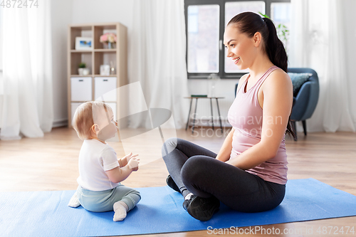 Image of happy mother with little baby at home