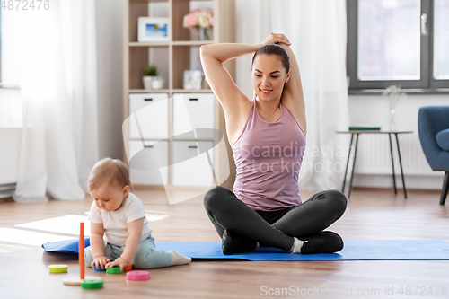 Image of happy mother with little baby exercising at home