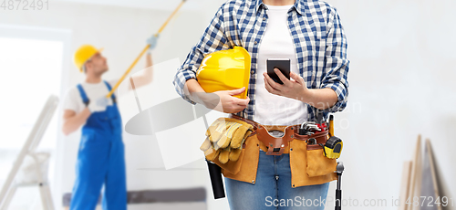 Image of woman or builder with phone and working tools