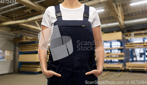 Image of close up of female worker in overall at factory