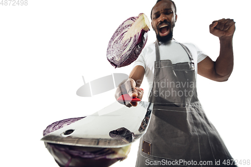 Image of Amazing african-american man preparing unbelievable food with close up action, details and bright emotions, professional cook. Cutting cabbage on the fly