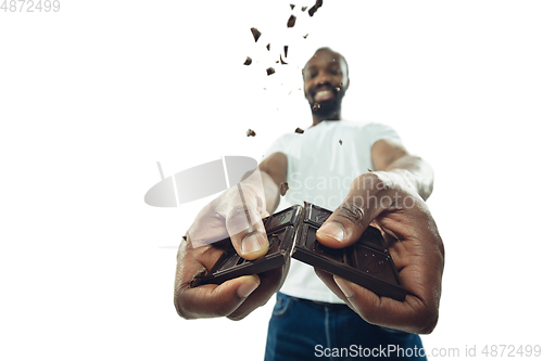 Image of Amazing african-american man preparing unbelievable food with close up action, details and bright emotions, professional cook. Cracking chocolate