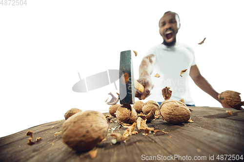 Image of Amazing african-american man preparing unbelievable food with close up action, details and bright emotions, professional cook. Cracking nuts