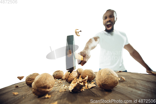 Image of Amazing african-american man preparing unbelievable food with close up action, details and bright emotions, professional cook. Cracking nuts