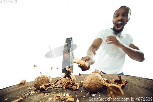 Image of Amazing african-american man preparing unbelievable food with close up action, details and bright emotions, professional cook. Cracking nuts