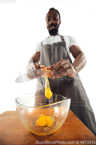 Image of Amazing african-american man preparing unbelievable food with close up action, details and bright emotions, professional cook. Preparing omelet, mixing eggs