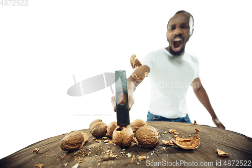 Image of Amazing african-american man preparing unbelievable food with close up action, details and bright emotions, professional cook. Cracking nuts