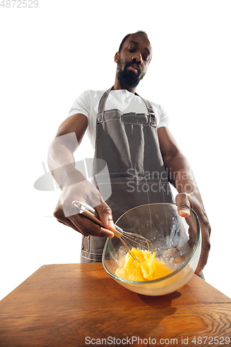 Image of Amazing african-american man preparing unbelievable food with close up action, details and bright emotions, professional cook. Preparing omelet, mixing eggs