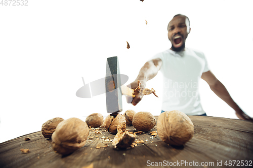 Image of Amazing african-american man preparing unbelievable food with close up action, details and bright emotions, professional cook. Cracking nuts