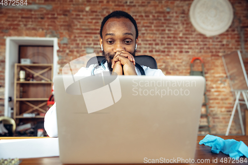 Image of Doctor advising the patient online with laptop. African-american doctor during his videocall, work with patients, explaining recipes for drug.