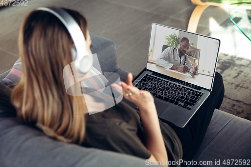 Image of Young woman getting online medical help and advice during videocall with doctor checking symtoms aand explaining the drug\'s reciepes