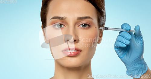 Image of beautiful young woman and hand with syringe