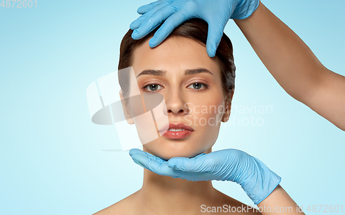 Image of beautiful young woman face and hand in gloves