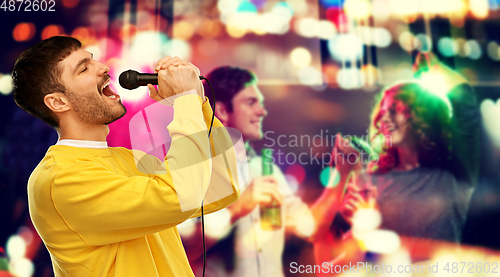 Image of man with microphone singing at night club