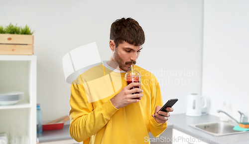 Image of man with smartphone and tomato juice