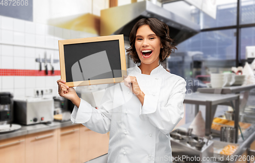 Image of happy female chef holding chalkboard at kebab shop