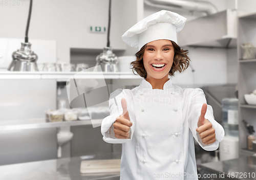 Image of smiling female chef in toque showing thumbs up