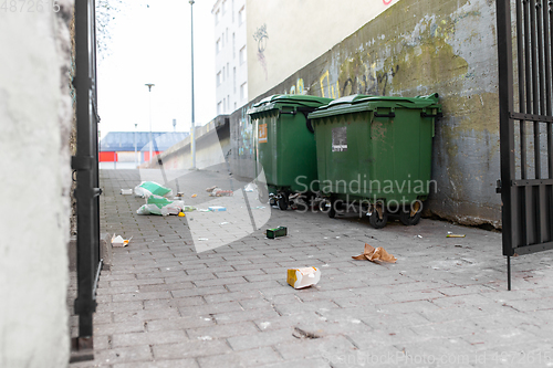 Image of dumpsters on messy city street or courtyard