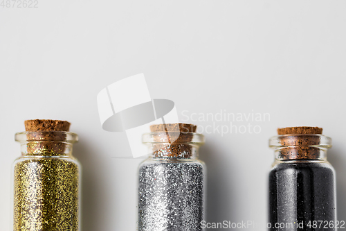 Image of set of glitters in bottles over white background