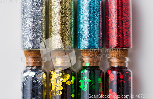 Image of set of glitters in bottles over white background