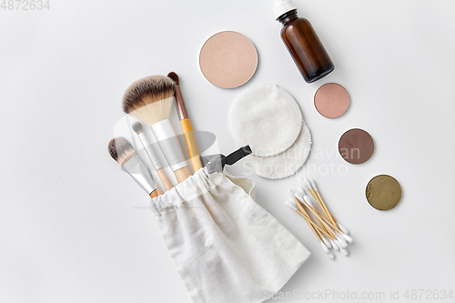 Image of make up brushes, cosmetics and cotton swabs