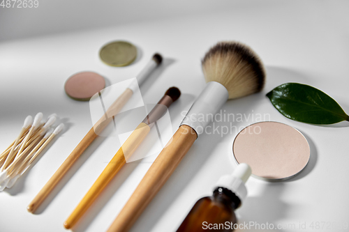 Image of make up brushes, cosmetics and cotton swabs