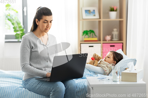 Image of ill daughter and mother with laptop at home