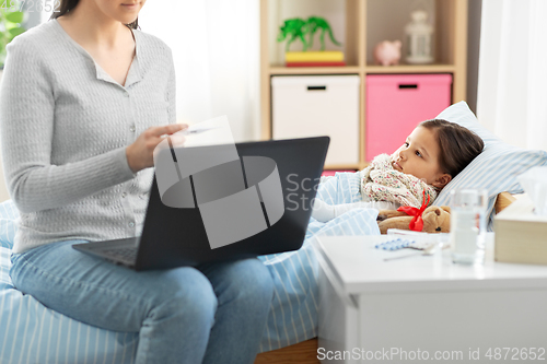 Image of ill daughter and mother with laptop at home